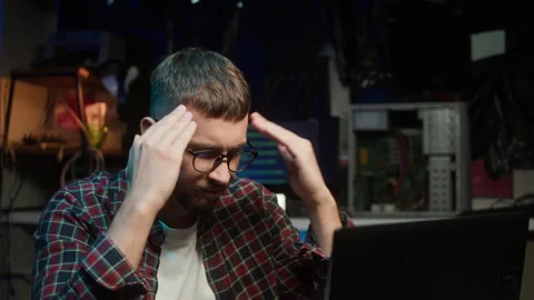 Hacker using laptop. Young man thinking about developing program. Professional Stock Footage 194009711