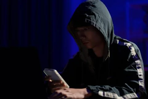 Hacker using smartphone for phishing attack and data theft in dark cyber Stock Photos