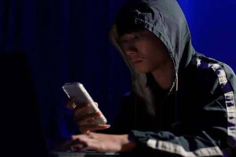 Hacker using smartphone for phishing attack and data theft in dark cyber Stock Photos