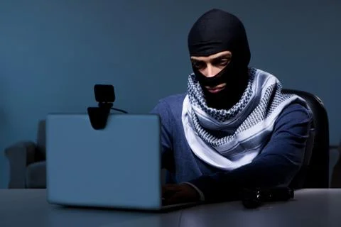 Hacker wearing balaclava mask hacking computer Foto stock
