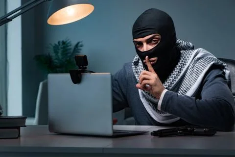 Hacker wearing balaclava mask hacking computer Stock Photos