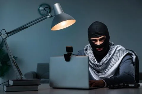 Hacker wearing balaclava mask hacking computer Foto stock