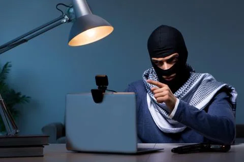 Hacker wearing balaclava mask hacking computer Stock Photos