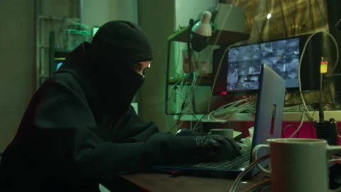 Hacker wearing balaclava stealing information from laptop, breaking password and Stock Footage 158164998