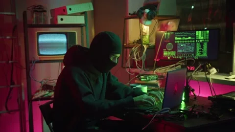 Hacker wearing balaclava stealing information from laptop, breaking password and 動画素材 158379923