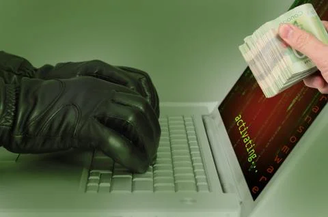 Hacker wearing black gloves using a laptop activating an attack using ransomw 스톡 사진