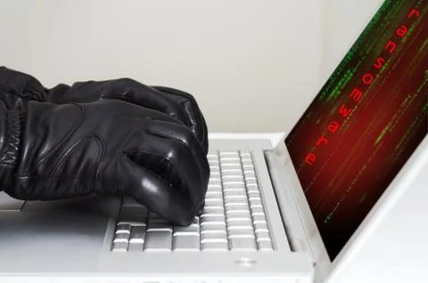 Hacker wearing black gloves using a laptop preparing to attack using ransomwa Foto stock