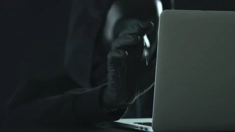 Hacker wearing black mask pulls PASSCODE tab from a laptop Video stock 138143463