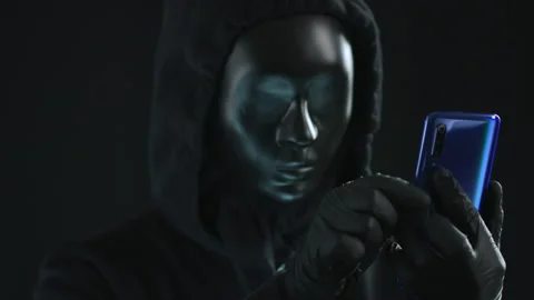 Hacker wearing black mask pulls MALWARE tab from a smartphone. Hacking concept Stock Footage 138145448