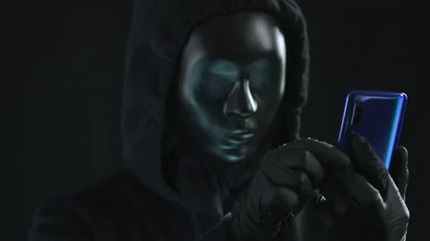 Hacker wearing black mask pulls SOURCE CODE tab from a smartphone. Hacking 스톡 동영상 138468335