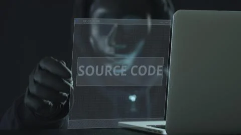 Hacker wearing black mask pulls SOURCE CODE tab from a laptop. Hacking concept Foto stock