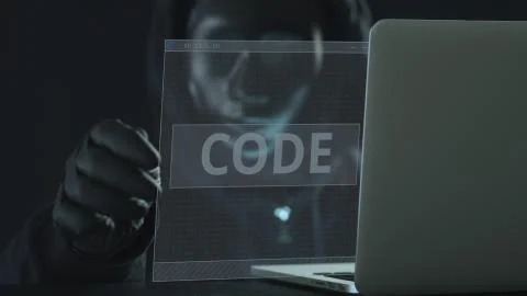 A hacker wearing black pulls CODE tab from a laptop. Hacking concept 스톡 사진
