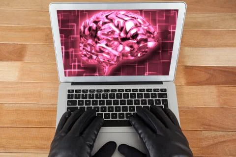 Hacker wearing gloves using a laptop  with a pink brain on desktop background Foto stock