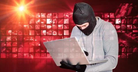 Hacker wearing monkey cap while using laptop 库存照片