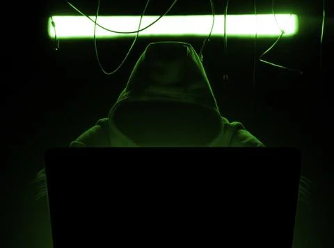 Hacker at work in the green gloomy lighting, 库存照片
