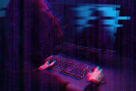 Hacker working with computer in dark room with digital interface around. Image Stock Photos
