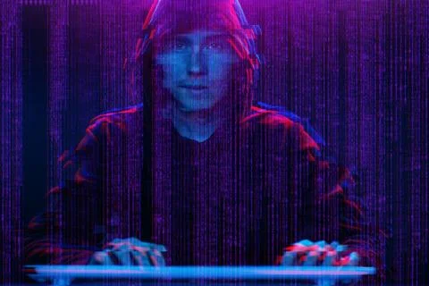 Hacker working with computer in dark room with digital interface around. Image Stock Photos
