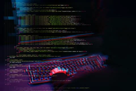 Hacker working with computer in dark room with digital interface around. Image Stock Photos