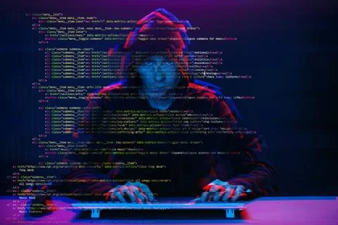 Hacker working with computer in dark room with digital interface around. Image 스톡 사진