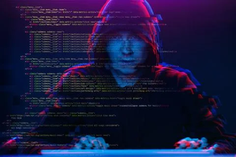 Hacker working with computer in dark room with digital interface around. Image Stock Photos