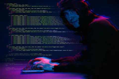 Hacker working with computer in dark room with digital interface around. Image 스톡 사진