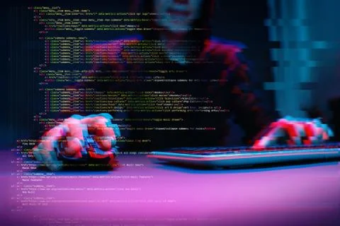 Hacker working with computer in dark room with digital interface around. Image Stock Photos