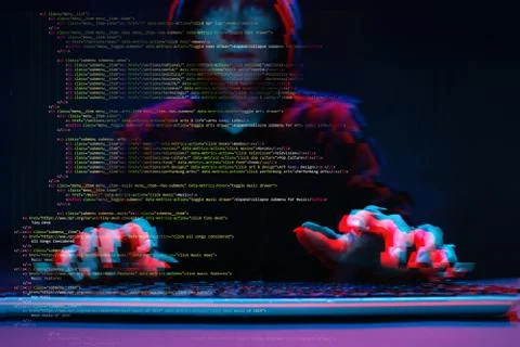 Hacker working with computer in dark room with digital interface around. Image Stock Photos