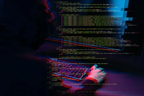 Hacker working with computer in dark room with digital interface around. Image Stock Photos