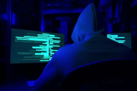Hacker working with computers in dark room, back view. Cyber attack 库存照片