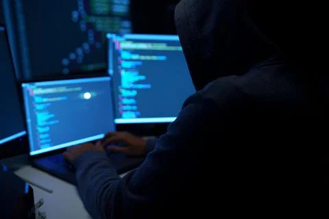 Hacker Working on Laptop with Code on Dark Screens Stock Photos