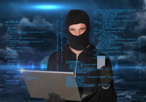 Hacker working on laptop in front of blue digital background Stock Photos