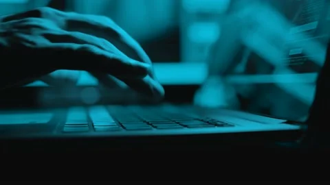 Hacker is working on laptop at night. Hands are typing a virus code at keyboard Stock Footage 134277671