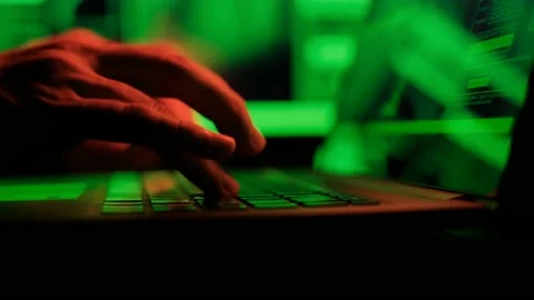 Hacker is working on laptop at night. Hands are typing a virus code at keyboard Stock Footage 147681089