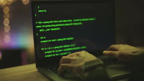 Hacker is working on laptop at night. Hands are typing a virus code at keyboard Video stock 154704727