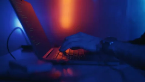 Hacker is working on laptop at night. Hands are typing a virus code at keyboard Stock Footage 164060547