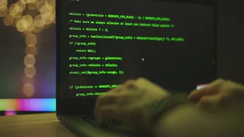 Hacker is working on laptop at night. Hands are typing a virus code at keyboard Stock Footage 168547506