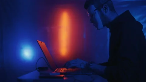 Hacker is working on laptop at night. Hands are typing a virus code at keyboard Stock Footage 168854818