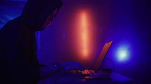 Hacker is working on laptop at night. Hands are typing a virus code at keyboard Stock Footage 220812209