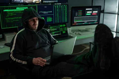 Hacker working on laptop stealing data from computer system Stock Photos