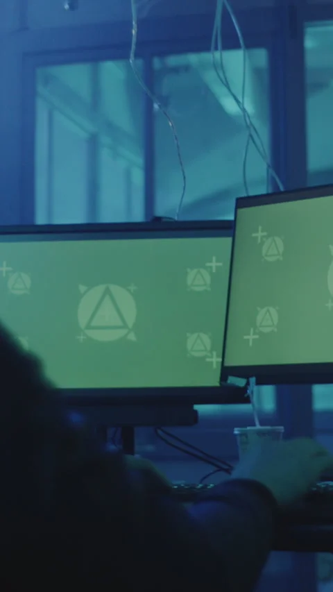 Hacker working on monitors with green screens and tracking software for visual Stock Footage 333394969