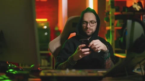 Hacker writing code cracking computer. Man programmer in hoodie cracks system Stock Footage 272909087