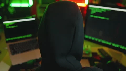 Hacker writing code cracking computer. Man programmer in hoodie cracks system Stock Footage 272909320