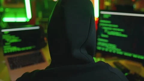 Hacker writing code cracking computer. Man programmer in hoodie cracks system Stock Footage 272909483
