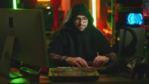 Hacker writing code cracking computer. Man programmer in hoodie cracks system Stock Footage 272909588