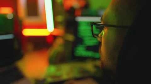 Hacker writing code cracking computer. Man programmer in hoodie cracks system Stock Footage 272910584