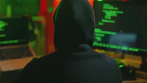 Hacker writing code cracking computer. Man programmer in hoodie cracks system Stock Footage 273512133