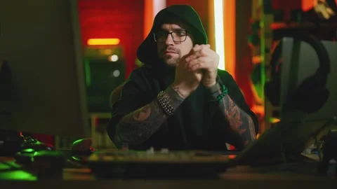 Hacker writing code cracking computer. Man programmer in hoodie cracks system Stock Footage 273512152