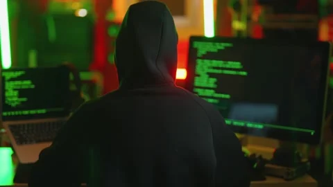 Hacker writing code cracking computer. Man programmer in hoodie cracks system Stock Footage 273678427