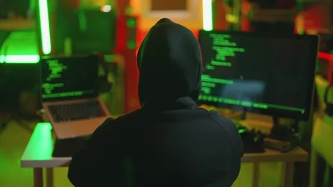 Hacker writing code cracking computer. Man programmer in hoodie cracks system Stock Footage 274055575