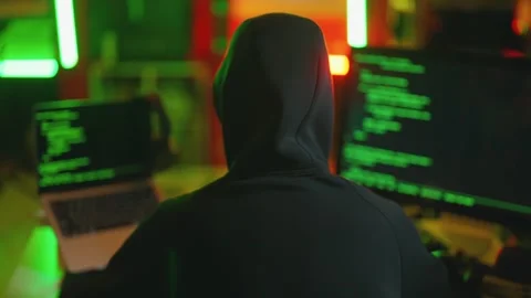 Hacker writing code cracking computer. Man programmer in hoodie cracks system Stock Footage 274132922
